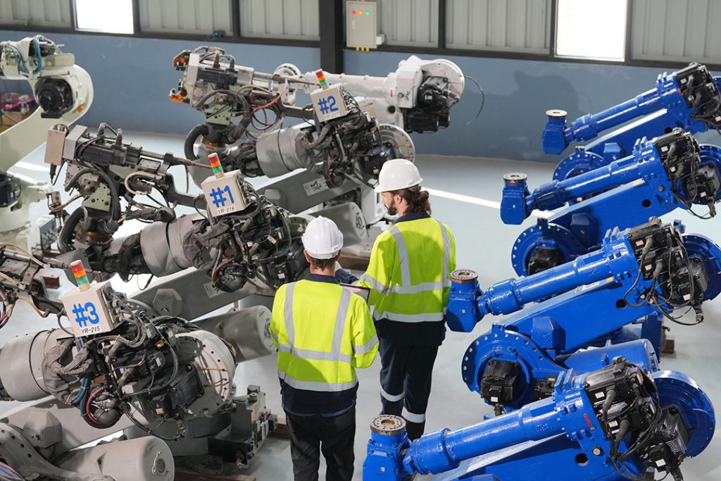 Robotics Precision Machining Services - engineers inspect robots in an industrial setting