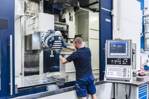 man working on machine in industrial factory