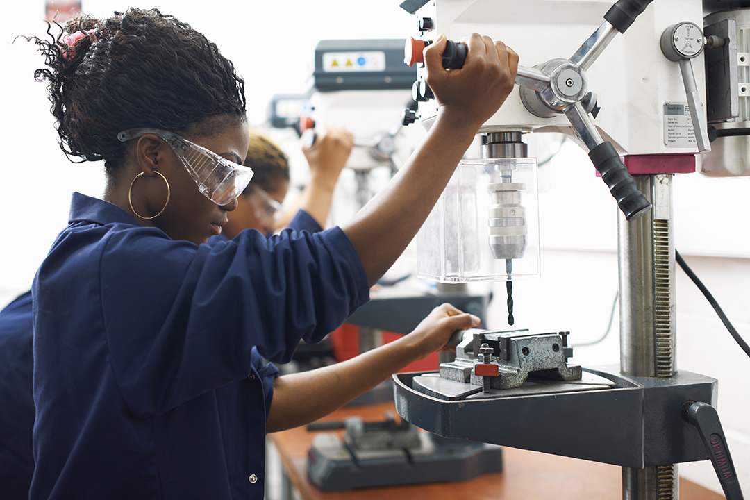 students using drilling machines in college workshop